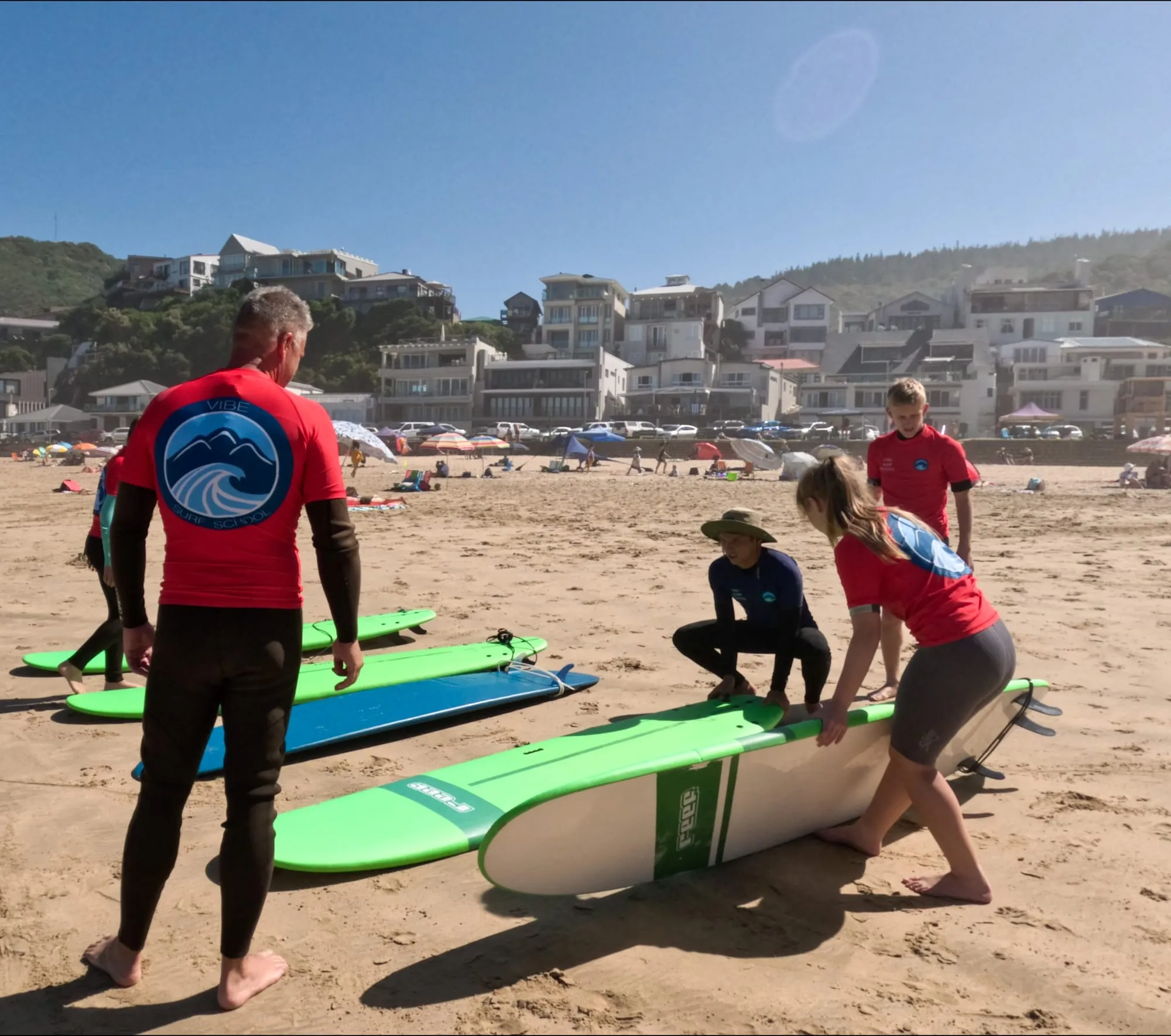 Vibe Surf School instructors with students and boards on the beach